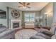 Comfortable living room featuring a fireplace, ceiling fan, hardwood floors, and natural light at 105 Silver Trce, Dallas, GA 30157