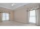 Bright primary bedroom featuring large windows, tray ceilings, and plush neutral carpeting at 1239 Brentwood Ct, Douglasville, GA 30135
