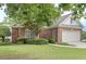 Brick home with an attached two car garage and manicured lawn at 1239 Brentwood Ct, Douglasville, GA 30135