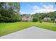 Spacious, green backyard featuring a concrete patio and a tree-lined perimeter for privacy at 3609 Indigo Creek Nw Trl, Kennesaw, GA 30144
