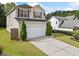 Charming two-story home with a well-maintained lawn, a long driveway, and an attached two-car garage at 3609 Indigo Creek Nw Trl, Kennesaw, GA 30144