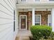 Inviting covered front porch with stone accents, elegant lighting, and a stylish front door at 3609 Indigo Creek Nw Trl, Kennesaw, GA 30144