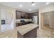 Kitchen features dark wood cabinets, stainless appliances, a granite countertop island, and tiled flooring at 3609 Indigo Creek Nw Trl, Kennesaw, GA 30144