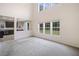 Spacious living room with large windows and neutral carpet, connected to the modern kitchen for seamless living at 3609 Indigo Creek Nw Trl, Kennesaw, GA 30144