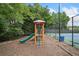 Community playground features a slide and climbing structure, with a tennis court in the background at 3609 Indigo Creek Nw Trl, Kennesaw, GA 30144