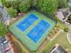 Aerial view of blue and green community tennis courts surrounded by greenery and parking at 3609 Indigo Creek Nw Trl, Kennesaw, GA 30144