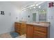Bathroom featuring double sink vanity, tile floors, large mirror with vanity lighting and modern fixtures at 493 Whaleys Lake Dr, Jonesboro, GA 30238