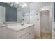 Bright bathroom featuring a white vanity, mirror, and a view of the shower and tile flooring at 493 Whaleys Lake Dr, Jonesboro, GA 30238