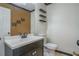 Compact half bathroom with floating shelves, white fixtures, tile flooring and a decorative mirror at 493 Whaleys Lake Dr, Jonesboro, GA 30238