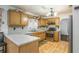 Well-lit kitchen features wood cabinets, wood floors, a gas range and a granite countertop on the breakfast bar at 493 Whaleys Lake Dr, Jonesboro, GA 30238