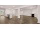 Open-concept living room with hardwood floors, fireplace and view to kitchen at 1179 Blue Juniper Cir, Loganville, GA 30052