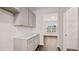 Pantry with white shelves next to the bright room and hardwood floors at 1179 Blue Juniper Cir, Loganville, GA 30052