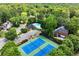 A dynamic aerial view of the community pool and tennis courts nestled between beautiful homes and trees at 220 Webley Ln, Alpharetta, GA 30022