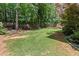 Expansive backyard featuring lush green grass and mature trees, providing ample space for recreation and relaxation at 220 Webley Ln, Alpharetta, GA 30022