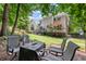 Landscaped backyard with comfortable seating around a fire pit, offering a cozy and inviting outdoor space at 220 Webley Ln, Alpharetta, GA 30022