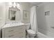Modern bathroom with a white vanity, marble countertop, and tiled shower with a tub at 220 Webley Ln, Alpharetta, GA 30022