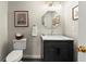 Charming half bathroom featuring a toilet, vanity, mirror, lighting, and wall art at 220 Webley Ln, Alpharetta, GA 30022