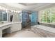 Modern bathroom with a corner soaking tub, glass enclosed shower, and dual sink vanity at 220 Webley Ln, Alpharetta, GA 30022