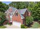 Traditional two-story brick home featuring manicured landscaping and an attached two-car garage at 220 Webley Ln, Alpharetta, GA 30022