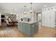Bright eat-in kitchen featuring a large center island with granite countertops and modern pendant lighting at 220 Webley Ln, Alpharetta, GA 30022
