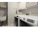 Bright laundry room with updated washer and dryer and shelving at 220 Webley Ln, Alpharetta, GA 30022
