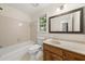 Bathroom with a tiled tub, vanity, and a view of the outdoors from the window at 127 Roe Hampton Ln Ln, Stone Mountain, GA 30087
