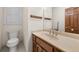 Bathroom features wood cabinets, a large mirror and a toilet at 127 Roe Hampton Ln Ln, Stone Mountain, GA 30087