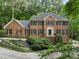 Beautiful brick home with mature trees, black shutters, and professionally landscaped front yard at 127 Roe Hampton Ln Ln, Stone Mountain, GA 30087