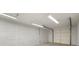 Bright, unfinished garage with a secure door and overhead lighting at 127 Roe Hampton Ln Ln, Stone Mountain, GA 30087