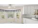 Charming kitchen nook with bay window, flooding the space with natural light and complementing the white cabinetry at 127 Roe Hampton Ln Ln, Stone Mountain, GA 30087