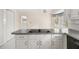 Kitchen features white cabinets and an island with a cooktop at 127 Roe Hampton Ln Ln, Stone Mountain, GA 30087
