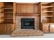 Close-up of a brick fireplace flanked by built-in wooden cabinets and shelving units at 127 Roe Hampton Ln Ln, Stone Mountain, GA 30087