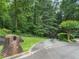 Charming home address marker at the foot of a winding driveway entrance lined with mature trees at 127 Roe Hampton Ln Ln, Stone Mountain, GA 30087