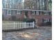 Charming brick home featuring a manicured lawn, white picket fence, and mature trees at 2289 Addison Rd, Marietta, GA 30066