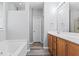Bathroom with double sink vanity, tub, shower, and warm wood cabinets at 930 Silver Lake Dr, Acworth, GA 30102
