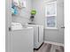 Bright laundry room featuring a washer, dryer, shelving, and a window for natural light at 930 Silver Lake Dr, Acworth, GA 30102