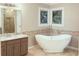 Bathroom featuring a freestanding tub, decorative windows, and tiled walk-in shower at 11575 Wildwood Springs Dr, Roswell, GA 30075