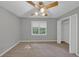 Spacious bedroom features a ceiling fan, neutral paint, window, carpet, and closet at 11575 Wildwood Springs Dr, Roswell, GA 30075