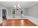 Dining room with hardwood floors, natural light, classic chandelier, and white wainscoting at 11575 Wildwood Springs Dr, Roswell, GA 30075