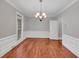 Dining room with hardwood floors, decorative chandelier, wainscoting, and natural light at 11575 Wildwood Springs Dr, Roswell, GA 30075