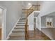 Bright foyer with hardwood floors, staircase, and view into a separate room at 11575 Wildwood Springs Dr, Roswell, GA 30075