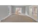 Spacious living room featuring neutral walls, carpet, and bright windows at 11575 Wildwood Springs Dr, Roswell, GA 30075