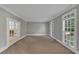 Bright living room with neutral walls, carpet, and bright windows at 11575 Wildwood Springs Dr, Roswell, GA 30075