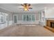 Bright living room featuring a ceiling fan, fireplace, built in bookshelves, and large windows at 11575 Wildwood Springs Dr, Roswell, GA 30075