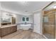 Elegant bathroom with a soaking tub, glass shower, dual vanities, and windows at 11575 Wildwood Springs Dr, Roswell, GA 30075