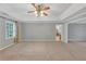 Spacious primary bedroom with tray ceilings, fan, and abundant natural light at 11575 Wildwood Springs Dr, Roswell, GA 30075