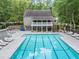Community pool with lounge chairs and nearby recreation, set amongst mature trees at 11575 Wildwood Springs Dr, Roswell, GA 30075