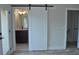 Bathroom featuring a white sliding barn door, dark vanity, and neutral tile at 293 White St # 2, Marietta, GA 30060