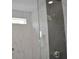 Walk-in shower with a fixed glass wall, white marble tile, and rain shower head at 293 White St # 2, Marietta, GA 30060