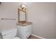 Bathroom features a vanity with granite top, decorative framed mirror, and white toilet at 297 Northgate Trce, Roswell, GA 30075